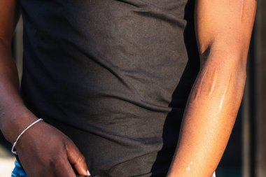 Siyah bluzlu, uzun kollu, güneş ışığıyla kaplı, tanınmayan bir mahsul.