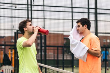 İki raket tenisçisi maçtan sonra dinleniyor.