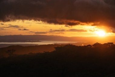 Kosta Rika kırsalında güzel bir gün batımı. Güneş dağlarda batar