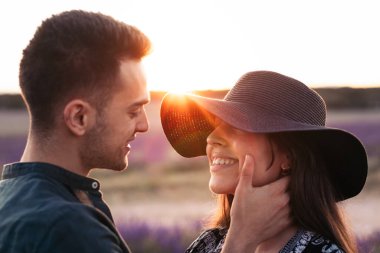 Tarlada birbirine aşık genç bir adam ve kadının günbatımını izlerken..