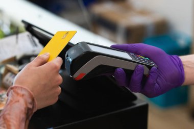 Kafedeki POS terminaline plastik kart ödemesi yapan tanınmamış bir kadın.