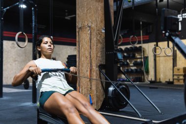 Spor salonunun yanındaki hafif spor salonundaki spor salonunda spor salonunda spor kıyafetlerini üst çıtada tutan güçlü İspanyol sporcu.