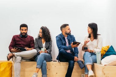 Mola sırasında gayri resmi bir toplantıda iş arkadaşları. Modern çalışma odasının dinlenme yerinde kahve içerken şirket verilerini tartışıyorlar.