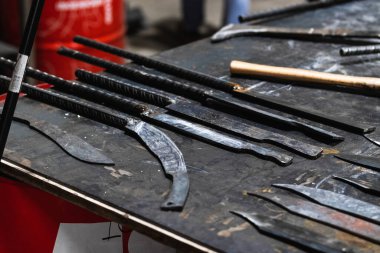 Çeşitli metal enstrümanların sıraları demirci masasına yerleştirildi.