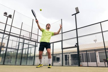 Genç adam raket tenisi oynuyor