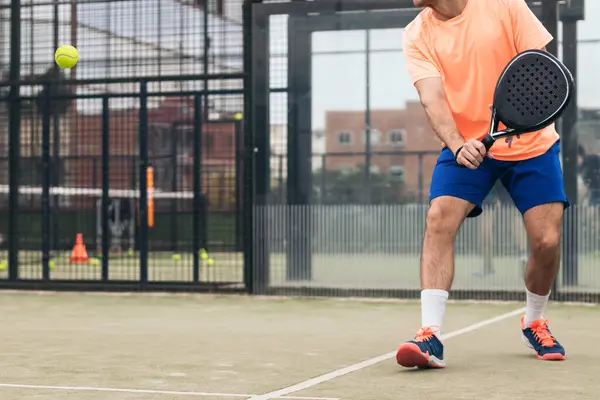 Genç adam raket tenisi oynuyor