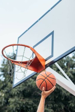 Tanınmayan basketbolcu sayı yapmak için potaya yaklaşıyor.