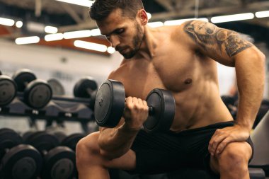 Dambılı kaslı adam antrenman kolu.