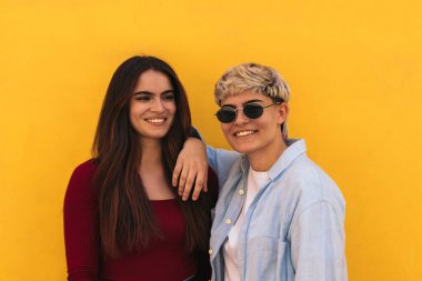 İki güzel genç kız gülümsüyor.