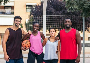 Sahadaki ırklar arası basketbol oyuncularının portresi. Spor giyimli dört arkadaş oyun oynuyor.