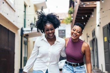 Tarz sahibi siyah kadın arkadaşlar eğleniyor ve gülüyorlar.