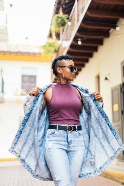 Kısa kıvırcık saçlı ve büyük küpeli havalı bir Afro-Amerikan kadının portresi