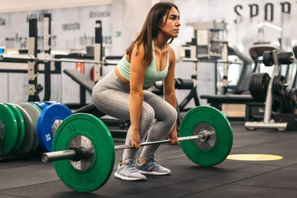 Spor salonunda kaldırma yapan kadın sporcu. yan görünüm