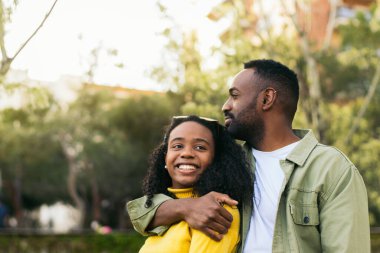 Siyah adam Afro-Amerikalı kadını kucaklıyor.