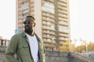 Güneş gözlüklü yakışıklı ve çekici Afro-Amerikan bir adam. Güneş ışığının yansımaları