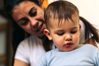 Anne bebeğiyle evde oturuyor.