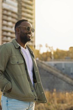 Güneş gözlüklü yakışıklı ve çekici Afro-Amerikan bir adam. Güneş ışığının yansımaları