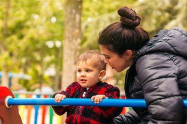 Anne ve bebek oyun parkında oynuyorlar.