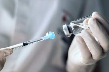 Enjeksiyon aşısı aşısı ilacı şırınga kadın hemşireye enjekte ediliyor. Yakın plan.