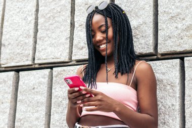 Şehirdeki akıllı telefonu kullanarak renkli genç bir kadının portresi.