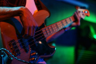 Hit the Note: Müzik grubu canlı konser sırasında kapalı bir sahnede renkli ışıklandırmayla şarkı söylüyor ve enstrümanlar çalıyor