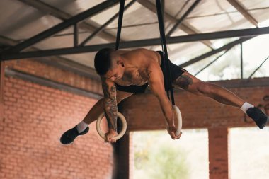 Jimnastik yüzükleriyle antrenman yapan bir sporcu.