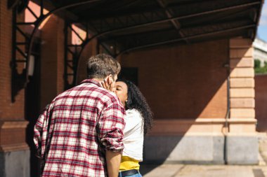 Çok ırklı genç bir çift istasyonda buluştuktan sonra sarılıp öpüşüyorlar. Yolculuğundan kalma mavi bir bavul taşıyor ve adam gülümsemesini bekliyor. Birbirlerini tekrar gördükleri için mutlular.