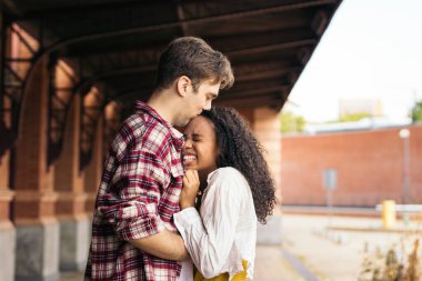 Çok ırklı genç bir çift istasyonda buluştuktan sonra sarılıp öpüşüyorlar. Yolculuğundan kalma mavi bir bavul taşıyor ve adam gülümsemesini bekliyor. Birbirlerini tekrar gördükleri için mutlular.