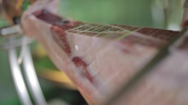 Tanımlanamayan aşçının bacağından iştah açıcı jamon eti kesmesi.