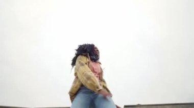 Düşük açılı Afrikalı Amerikalı kadın beton yolda dans ederken başını sallıyor.