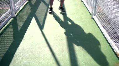 Active female athlete in sports clothes raising leg during workout while looking away on sunny day