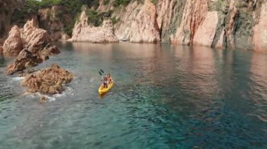 Denizde süzülen sporun sarı kano görüntüsü