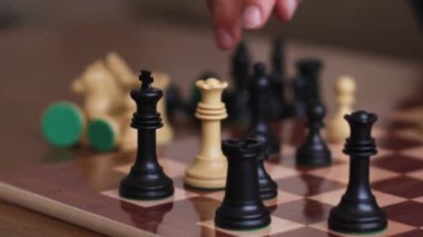 Kraliçe taşıyla satranç oynarken tanınmayan bir şahsın zaferi kazanması kralı evde kontrol altına alıyor.