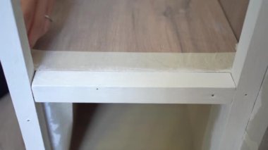 Evdeki yenileme işlemi sırasında kimliği belirsiz bir kadın merdivenlere beyaz bant yapıştırıyor.