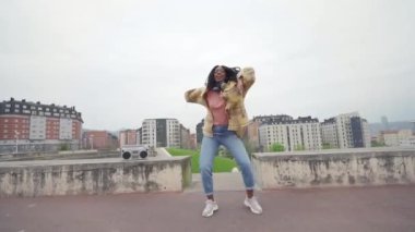 Alçak açılı Afrika kökenli Amerikalı kadın dansçı müzik eşliğinde dans ediyor.