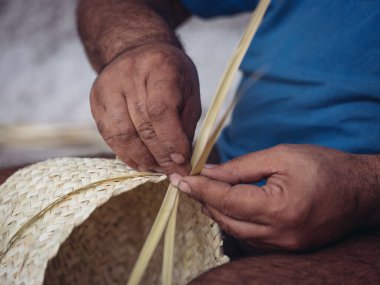 Bir zanaatkârın ellerinin titizlikle geleneksel bir palmito sepeti dokumasını yakından görmek, bu el yapımı sanat eserinin içeriğini gözler önüne seriyor.