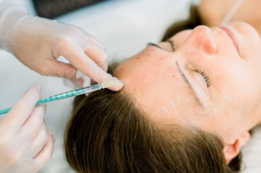 Bir hasta, klinik ortamdaki bir profesyonelden muhtemelen hiyalüronik asit ya da botoks gibi estetik bir iğne alır ve yüz estetiğini geliştirir.