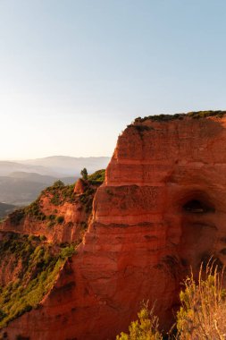 Güneşli bir günde bulutlu mavi gökyüzünün altında yosunlu engebeli tepelerin manzarası