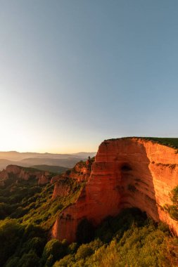 Güneşli bir günde bulutlu mavi gökyüzünün altında yosunlu engebeli tepelerin manzarası