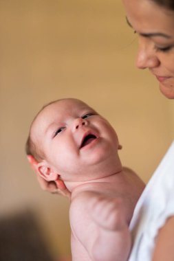 Ekin manzarası sakin genç bir kadının gündüz vakti tapılası bebeği kucaklaması ve okşaması.