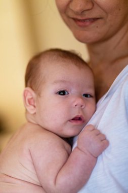 Ekin manzarası sakin genç bir kadının gündüz vakti tapılası bebeği kucaklaması ve okşaması.
