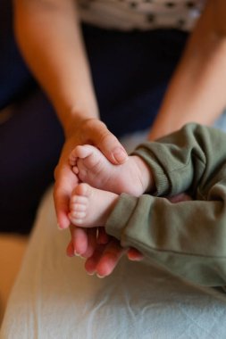 Anonim bir anneden gelen, güneşli bir sabahta çıplak ayakla küçük ayaklara masaj yapan bir hasattan.