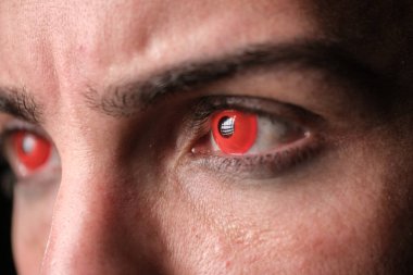 Macro shot focusing on a person's eyes with red contact lenses suggesting a halloween or cybernetic theme. clipart