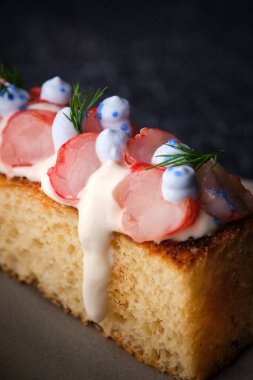 Lezzetli pastanın kapanışı, beyaz tılsımlı karideslerden oluşan brioche biberiyeyle süslenmiş ekmeğe damlıyor.