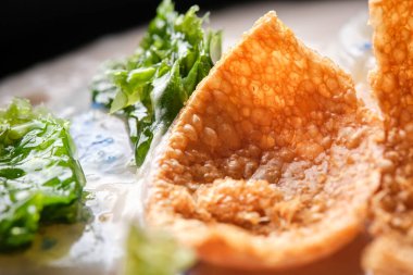 Lezzetli kızarmış peynir topu ve deniz tarağı soslu krema çorbası üzerine marul.