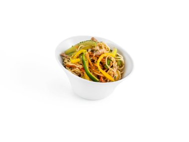 Canlı ve iştah açıcı bir et dilimleri, dolma biber ve yeşillik ile kızartılmış şehriye. Beyaz arka planda modern beyaz bir kâsede servis ediliyor. Sağlıklı bir yemek için mükemmel.