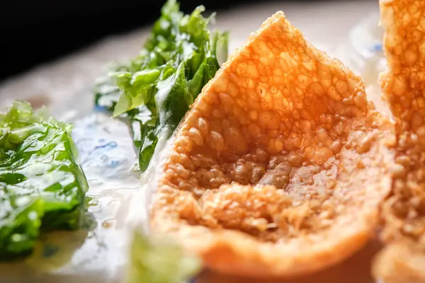 Lezzetli kızarmış peynir topu ve deniz tarağı soslu krema çorbası üzerine marul.