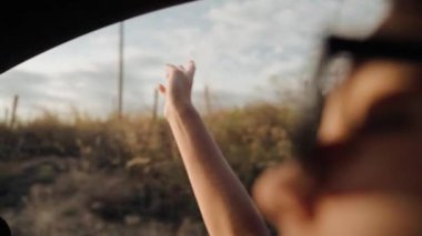 Sıcak, manzaralı bir fotoğraf. Bir kadının yaz gezintisi sırasında güneş ışığıyla aydınlanmış kırsal bir alana bakışını gösteriyor.