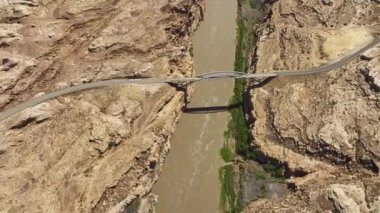 Beyaz Kanyon 'un engebeli arazilerindeki Colorado Nehri' ni kaplayan ve ABD 'nin Glen Kanyonu Ulusal Dinlenme Bölgesi' nde bulunan bir köprüyü çeken bir hava görüntüsü.