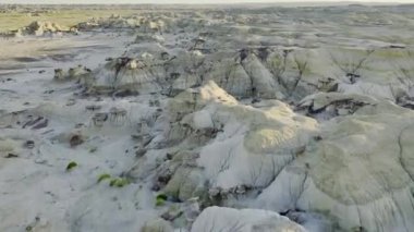 Bisti Çorak Toprakları 'nın karmaşık peyzajını gösteren hava görüntüsü. Karmaşık kaya desenleri, bastırılmış toprak tonları ve dağınık bitki örtüsü.